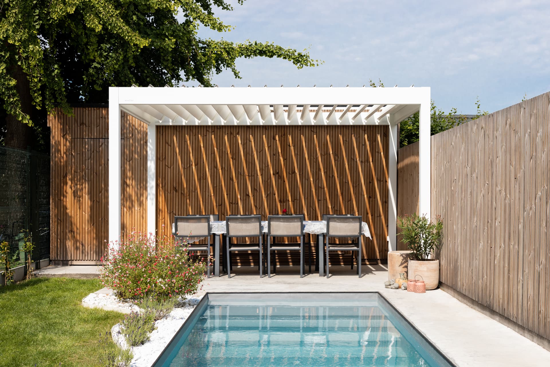 Eine moderne Lamellenpergola neben einem Swimmingpool