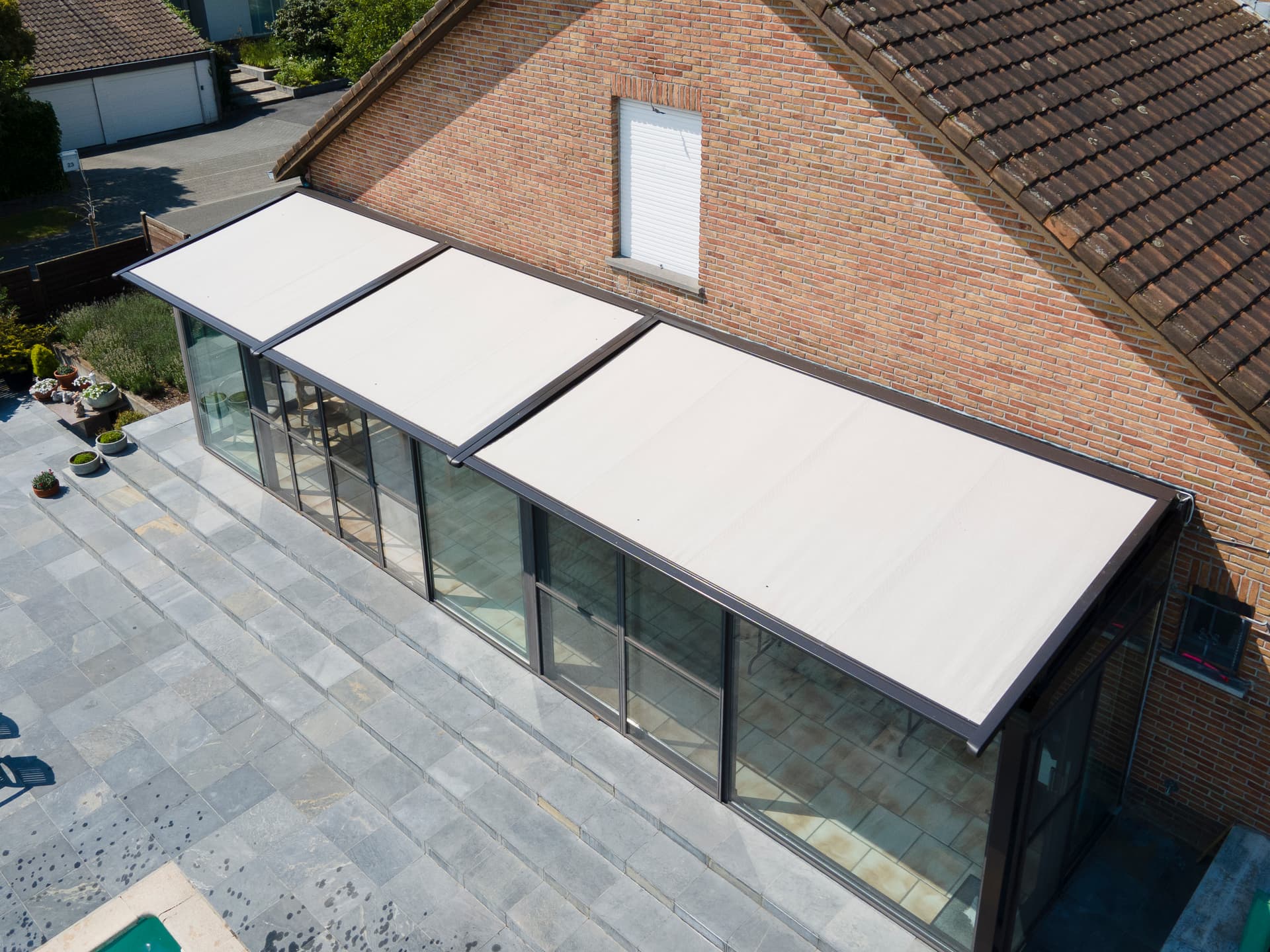 Brustor B126 conservatory awning mounted above a rectangular glass veranda roof, providing exterior sun protection along the full structure
